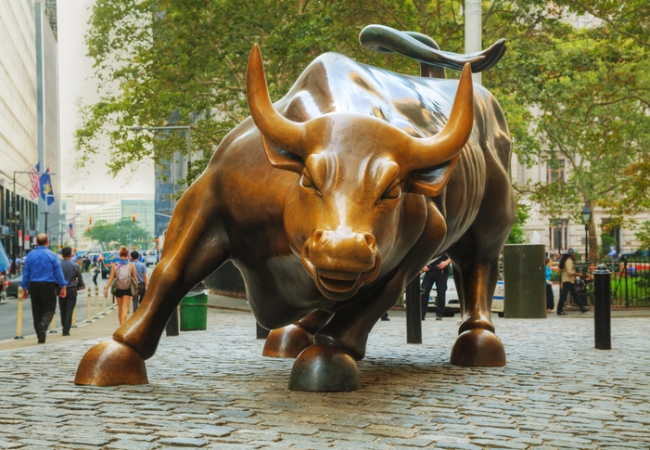 Charging Bull sculpture with people on September 3, 2015 in New York City. The sculpture is both a popular tourist destination, as well as "one of the most iconic images of New York".