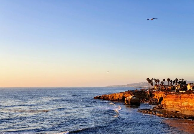 Sunset over a beautiful San Diego beach with families enjoying the outdoors, representing the city's coastal lifestyle.