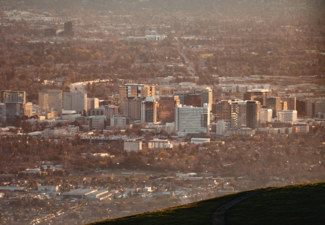 View of Silicon Valley with modern tech campuses and scenic mountains in the distance, symbolizing San Jose’s innovation-driven economy and tech scene.