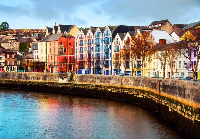 A vibrant street in Cork with colorful buildings, local shops, and a lively atmosphere.