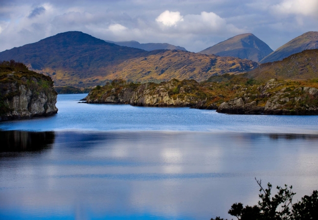 A breathtaking landscape of Killarney National Park with lush greenery, lakes, and mountains.