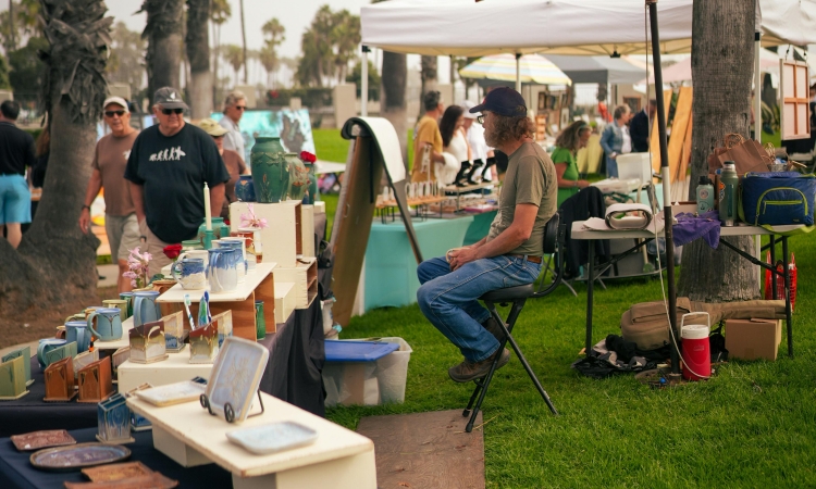 An organized estate sale setup with neatly arranged furniture, antiques, and household items, attracting potential buyers in a well-lit space.