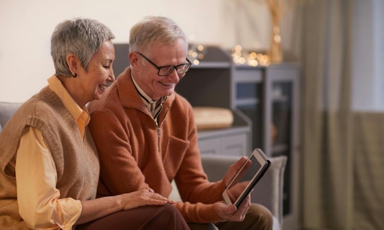 Senior couple happily in their home, organizing belongings and preparing for a move to a smaller, more accessible living space.